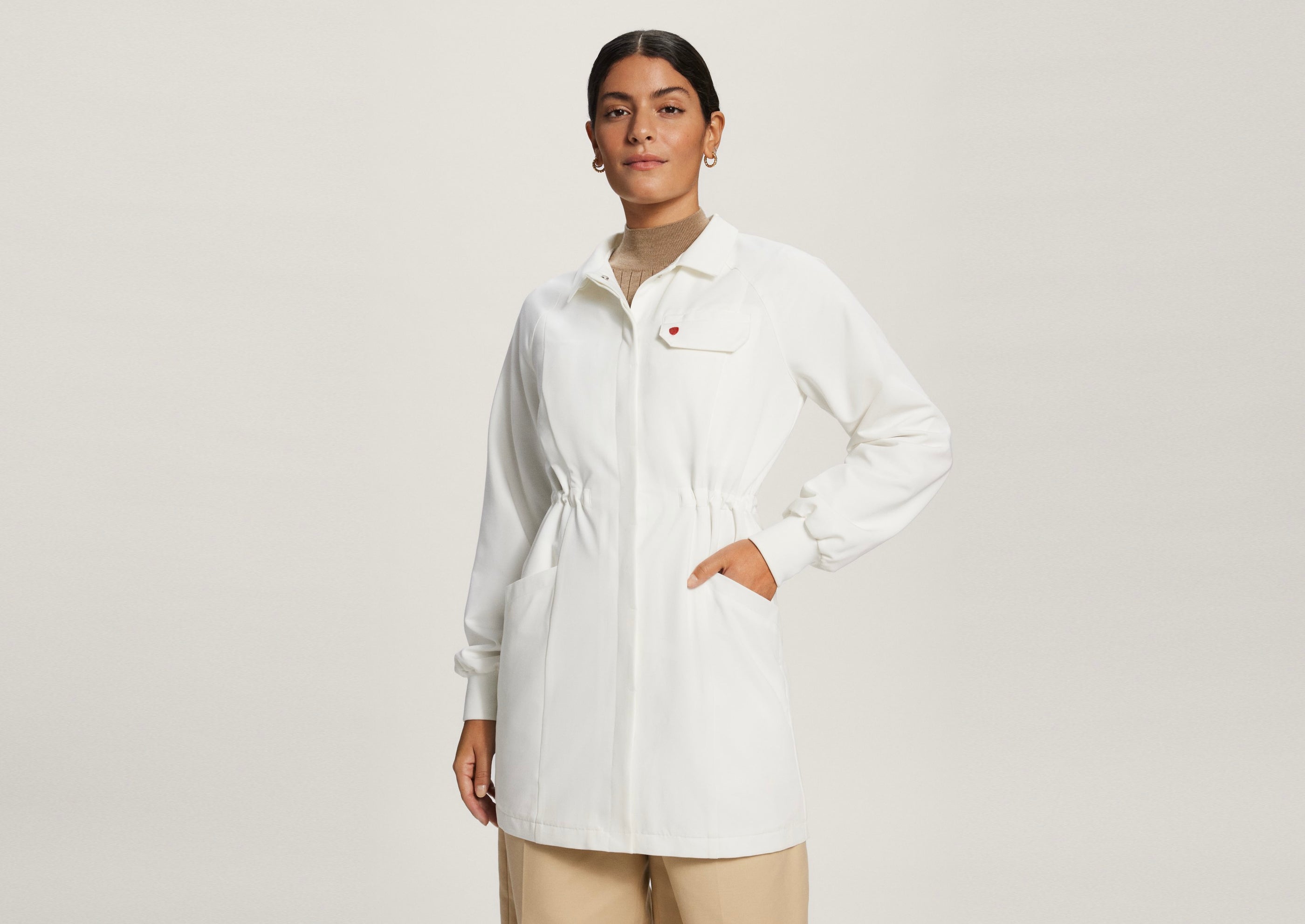 Three-quarter view of woman wearing AmorSui Lab Coat buttoned up with hand in pocket